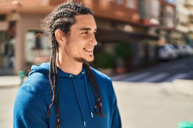 Sokakta kendine güvenen genç adam gülümsüyor