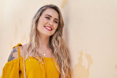 Genç bayan gülümsüyor sarı arka planda kendine güvenen tarafa bakıyor.