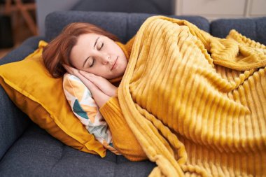 Young beautiful plus size woman lying on sofa sleeping at home