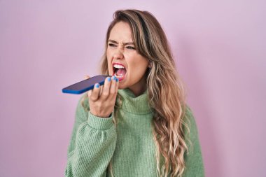 Kafkasyalı genç bir kadın akıllı telefonuyla öfkeli ve kızgın çığlıklar atan sinirli ve öfkeliydi. Öfkeyle bağırıyordu. öfke ve agresif konsept. 