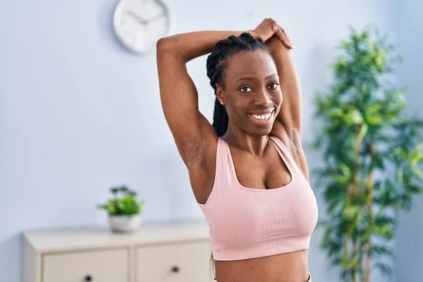 African american woman smiling confident stretching arms at home