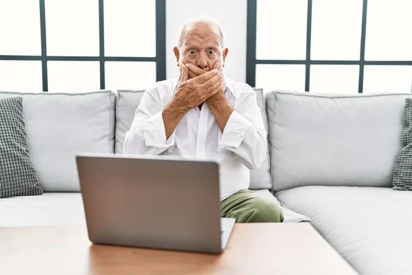Senior Man Using Laptop Home Sitting Sofa Shocked Covering Mouth — Stock Photo, Image