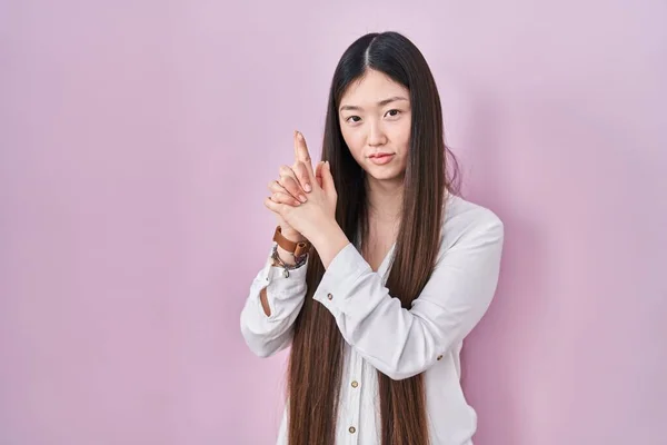 Mujer Joven China Pie Sobre Fondo Rosa Sosteniendo Arma Simbólica —  Fotos de Stock
