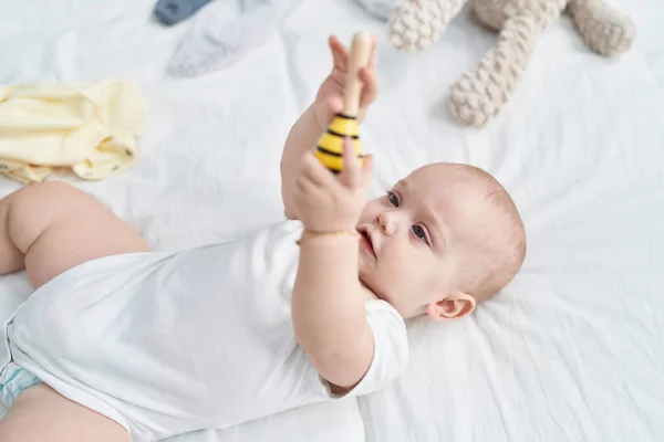 Beyaz Bebek Yatakta Uzanmış Yatak Odasında Maraca Oyuncağı Tutuyor — Stok fotoğraf