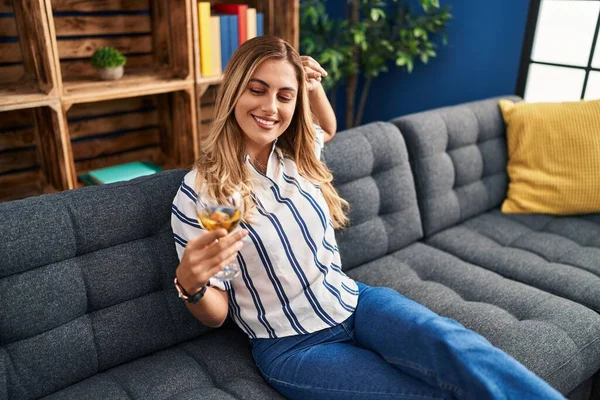 Young Blonde Woman Drinking Champagne Sitting Sofa Home — стоковое фото