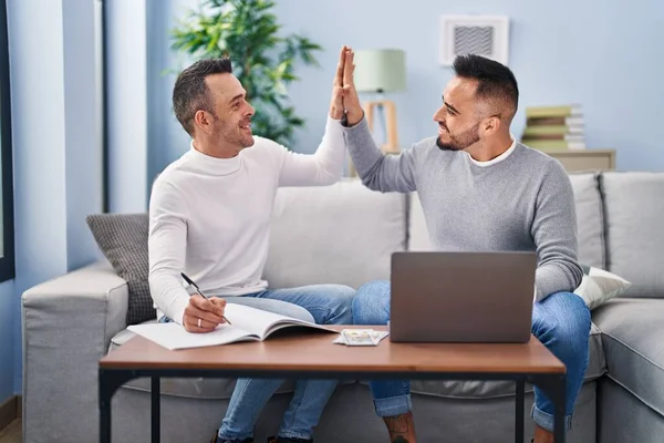 Two Men High Five Hands Raised Sitting Sofa Home — Stock Photo, Image