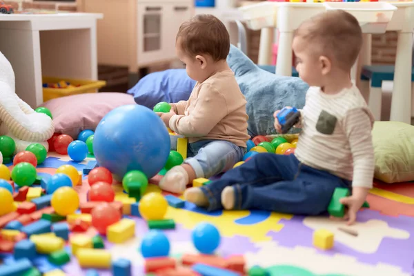 Två Bedårande Småbarn Leker Med Bollar Och Bil Sittande Golvet — Stockfoto