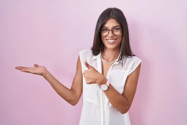 Brunette Young Woman Standing Pink Background Wearing Glasses Showing Palm — Stock fotografie