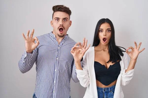 Young Hispanic Couple Standing White Background Looking Surprised Shocked Doing — Stock Photo, Image