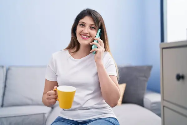 Young Hispanic Woman Drinking Coffee Talking Smartphone Home — Fotografia de Stock