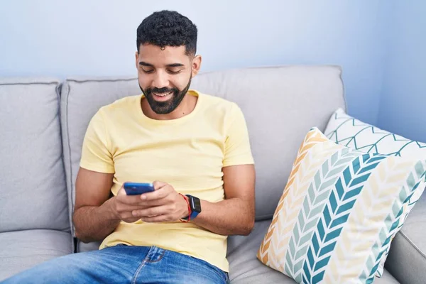 Young Arab Man Using Smartphone Sitting Sofa Home — ストック写真