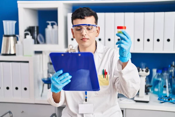 Young Non Binary Man Scientist Reading Report Holding Urine Test — Stockfoto