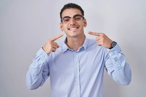 ビジネス用の服や眼鏡を身に着けているハンサムなヒスパニック系の男性は 陽気な表情と指の歯と口で指して笑顔 歯の健康の概念 — ストック写真