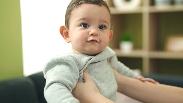 Bedårande Hispanic Baby Leende Säker Avslappnad Mor Händer Hemma — Stockfoto