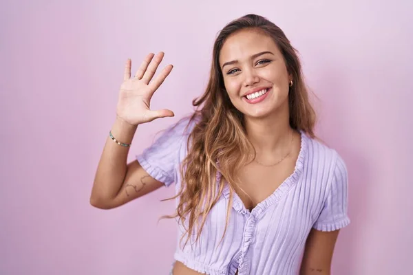 Молодая Латиноамериканка Стоящая Розовом Фоне Показывающая Пальцами Номер Пять Улыбаясь — стоковое фото