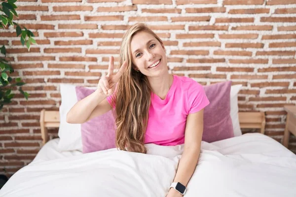 Young Blonde Woman Doing Victory Gesture Sitting Bed Bedroom — Stock Photo, Image