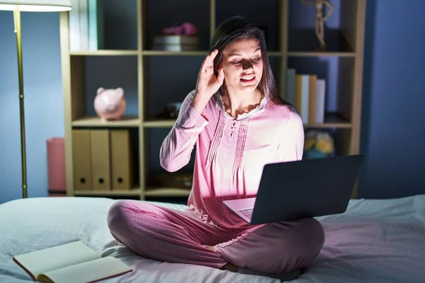 Young Hispanic Woman Using Computer Laptop Bed Smiling Hand Ear —  Fotos de Stock