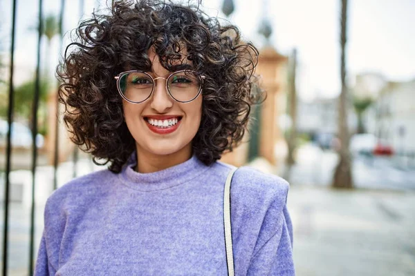 Young middle east woman smiling confident wearing glasses at street