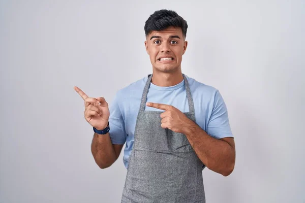 Hispanic Young Man Wearing Apron White Background Pointing Aside Worried — 图库照片