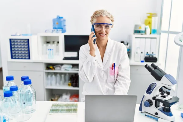 Middle Age Blonde Woman Wearing Scientist Uniform Talking Smartphone Working — Stock Photo, Image