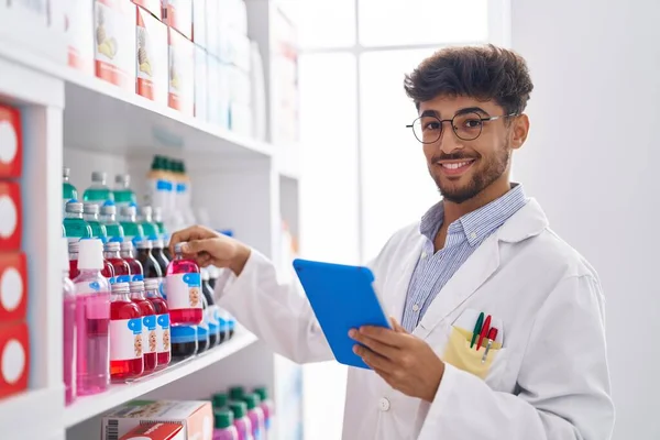 Young Arab Man Pharmacist Using Touchpad Holding Medicine Bottle Pharmacy — Foto de Stock