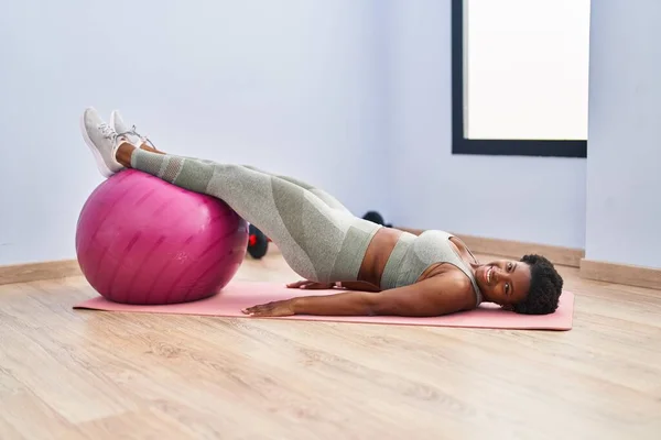African american woman smiling confident training abs exercise at sport center