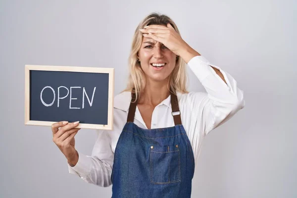 Young Blonde Woman Wearing Apron Holding Blackboard Open Word Stressed — Stockfoto