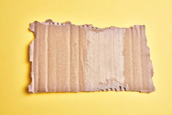 Jeden Porwany Kawałek Kartonu Izolowanym Żółtym Tle — Zdjęcie stockowe