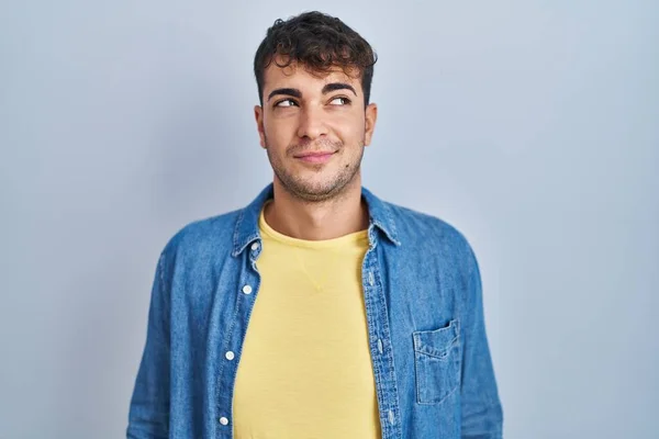 Young Hispanic Man Standing Blue Background Smiling Looking Side Staring — Stockfoto