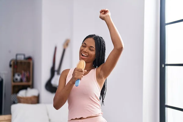African American Woman Singing Song Using Brush Microphone Bedroom — Stockfoto