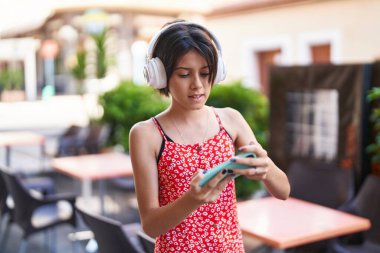 Sokakta konsantre ifadesiyle video oyunu oynayan sevimli İspanyol kız.