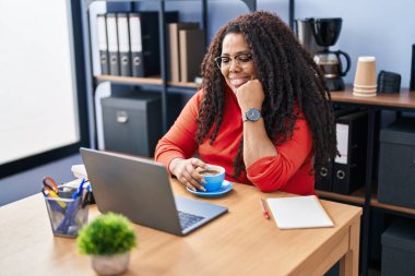 Ofiste çalışırken dizüstü bilgisayar kullanan Afrikalı Amerikalı iş kadını.