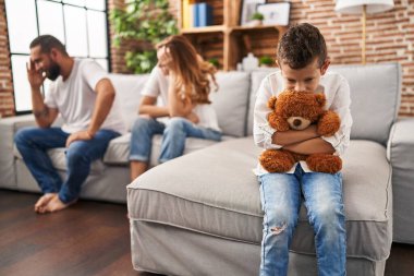 Family sitting on sofa and kid sad for partents argue at home clipart