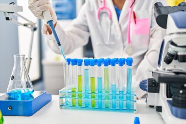 Young chinese woman wearing scientist uniform working at laboratory