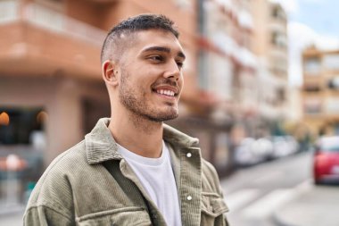 Sokakta kendinden emin gülümseyen İspanyol genç adam.