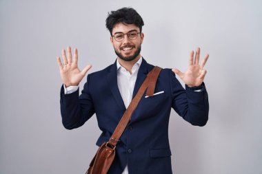 Sakallı, iş kıyafetleri giymiş İspanyol bir adam dokuz numaralı parmaklarıyla kendini beğenmiş ve mutlu gülümserken onu işaret ediyor.. 