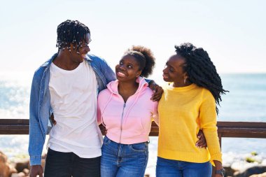 African american friends smiling confident hugging each other at seaside