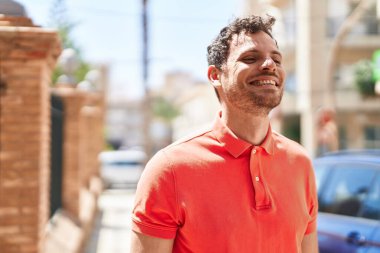 Sokakta kendinden emin gülümseyen İspanyol genç adam.