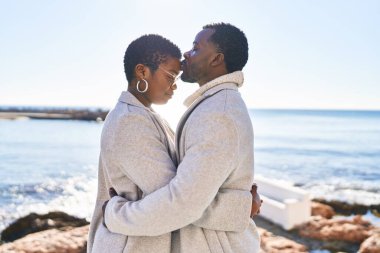 Man and woman couple hugging each other standing at seaside