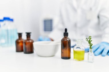 Laboratuvarda bilimsel havan topu kullanan yakışıklı İspanyol.