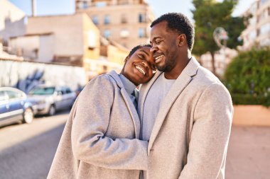 Man and woman couple hugging each other standing at street