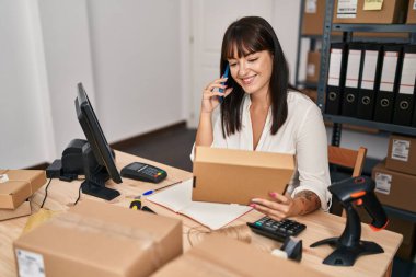 Genç, güzel, İspanyol bir kadın. İşadamı, ofisteki akıllı telefon paketinden konuşuyor.