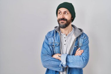 Yün şapkalı, gülümseyen, yan bakan ve düşünen dövmeli İspanyol bir genç.. 