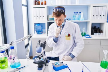 Caucasian man working at scientist laboratory feeling unwell and coughing as symptom for cold or bronchitis. health care concept. 
