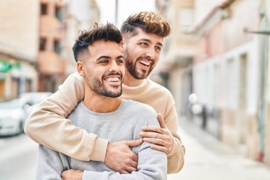 Young couple smiling confident hugging each other at street
