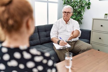 Danışma ofisindeki kıdemli psikolog neşeli bir gülümsemeyle avuç içi yardım ve kabullenme sunuyor.. 