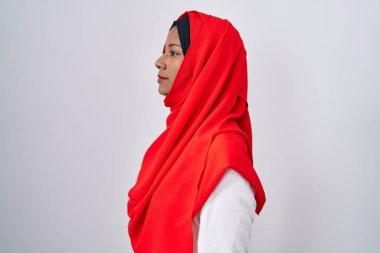 Young arab woman wearing traditional islamic hijab scarf looking to side, relax profile pose with natural face and confident smile. 
