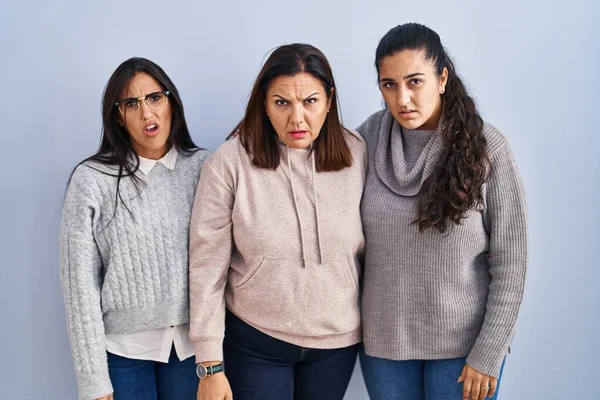 Mother Two Daughters Standing Blue Background Shock Face Looking Skeptical — Stockfoto