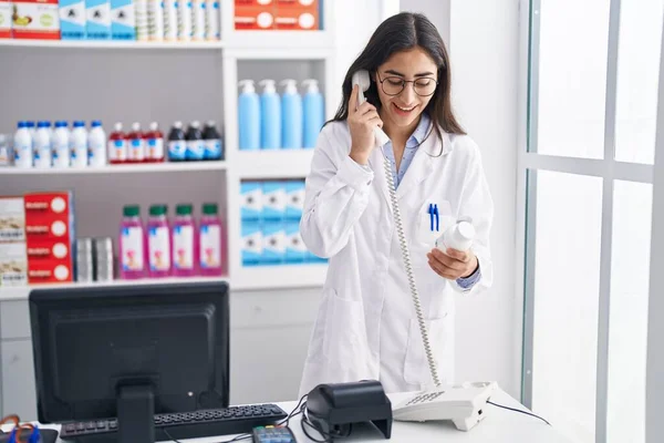 Young Hispanic Girl Pharmacist Talking Telephone Holding Pills Pharmacy — Foto de Stock