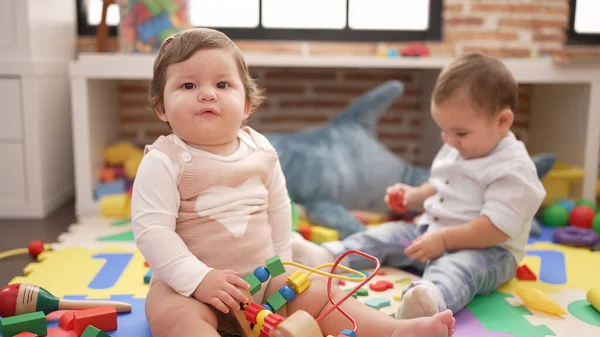 幼稚園の床に座っておもちゃで遊んでいる2人の幼児 — ストック写真